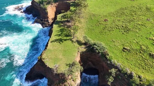 Aerial view of the rugged coastline, where turquoise waters meet a rocky cliffside topped with