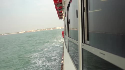Vista lateral de um navio de passageiros navegando pelo mar em perspectiva de primeira pessoa, em câmera lenta,