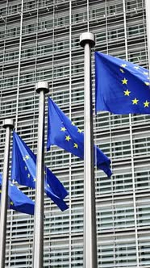 European Union Flags Waving Before Modern Building Facade