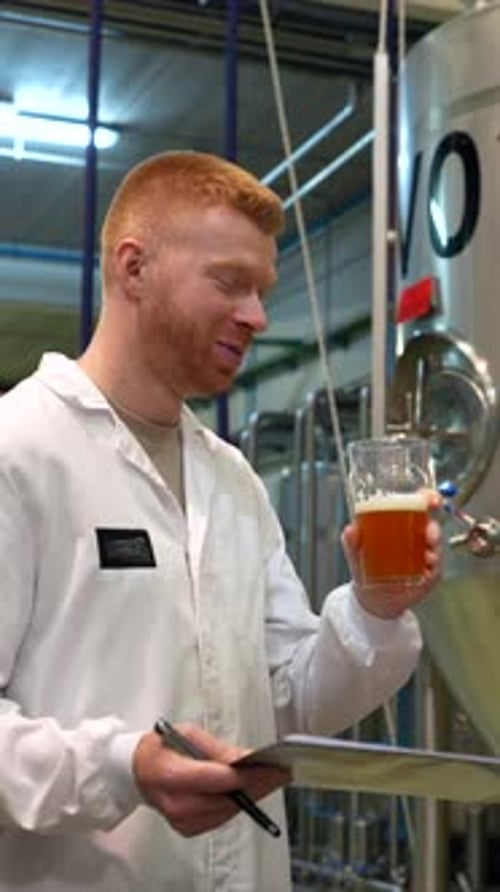 Master Brewer Tasting Fresh Beer From a Tank