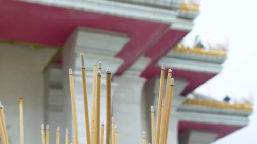 wind blowing burning incense with a local temple as a background