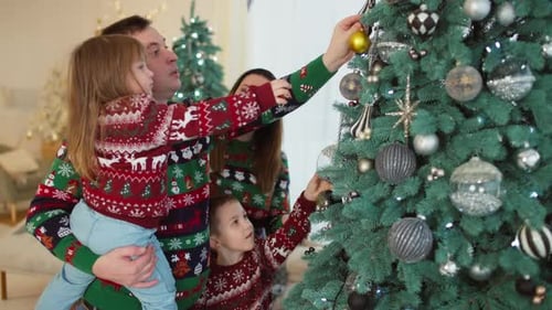 Family Decorates Christmas Tree with Love and Joy