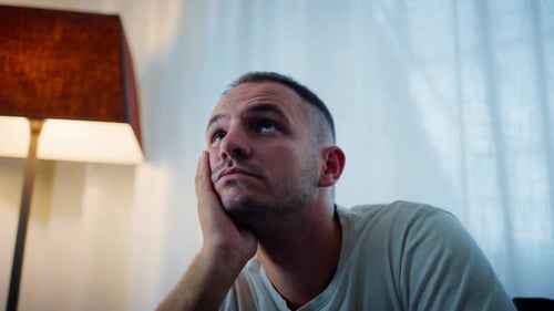 Pensive Man with Hand on Face Looks Upward