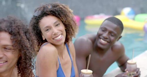 Biracial woman and African American man enjoy a pool party