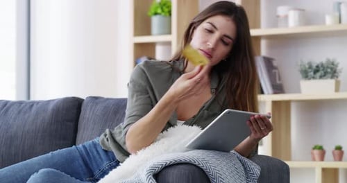 Woman Shops Online With Tablet on Couch