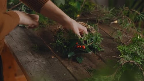 Woman creating Christmas wreath in workshop