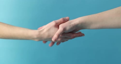 Two Hands Reaching and Grasping on Blue Background