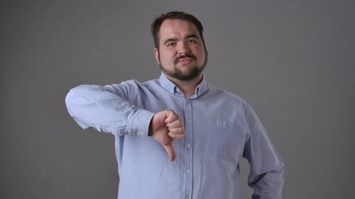 Man Showing Thumbs Down Gesture with Neutral Expression
