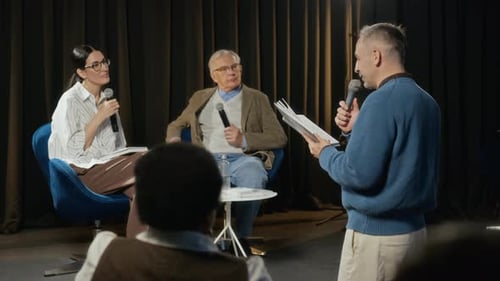 Hombre presenta un libro al panel de oradores en una conferencia de prensa