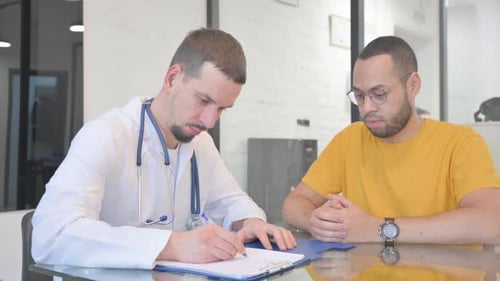 Young Doctor Discussing Medical Report with Patient in Clinic