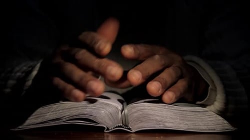 Schwarzer Mann betet und liest die Bibel auf einer Tischplatte: Stockvideos: Stock-Bildmaterial