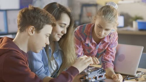 Two Girls and a Boy Program Robot for School Science Class Project.
