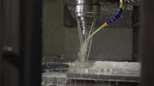 CNC Machine Coolant Spray Over Metal Workpiece