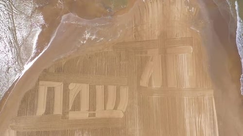 Happy Holiday in Hebrew letters written in Sand on a beach, Aerial view
