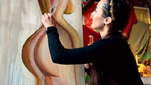 Beautiful woman painting with watercolors at an art gallery workshop