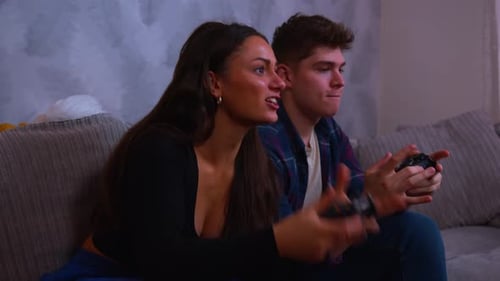 Excited Couple Playing Video Games on Couch