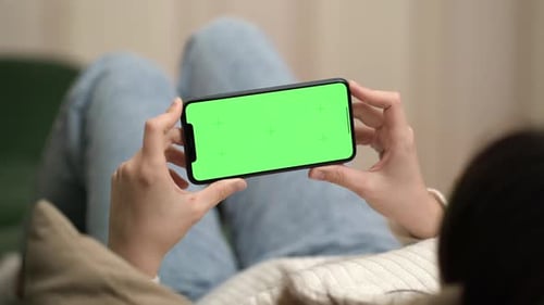 Woman Lying on Sofa Resting and Using Phone with Green Screen and Chroma Key
