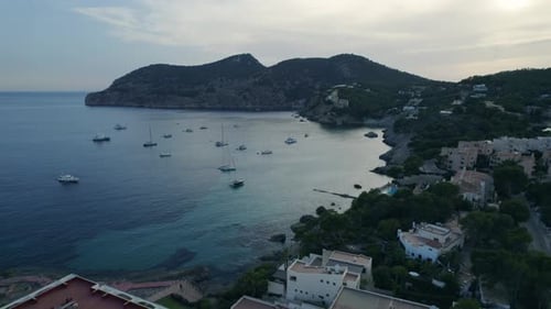 Twilight drone view of coastal bay and marina in Mallorca, Spain with yachts.
