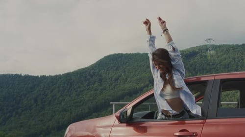 Woman Enjoys View From Car Window on Road Trip