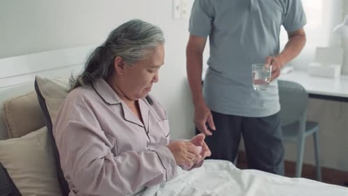 Senior Woman Takes Pill with Water