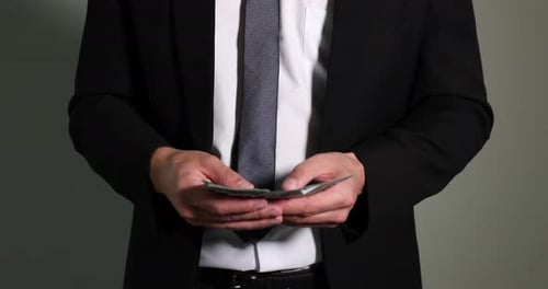 Man in Suit Counting and Stashing Money