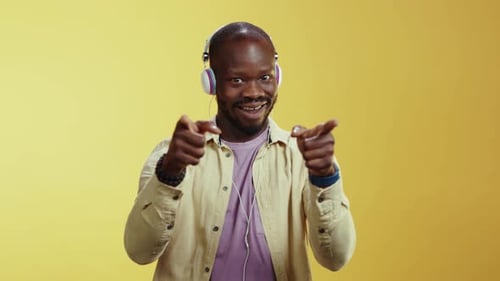 A Joyful Man Dances to Music in a Vibrant Yellow Background