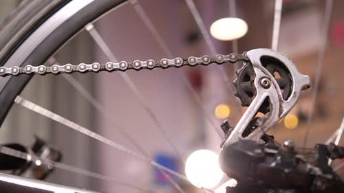 Closeup of a Dirty Bicycle Chain Against the Background of a Spinning Wheel