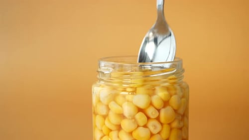 Spoon Pick Sweet Corn From a Container