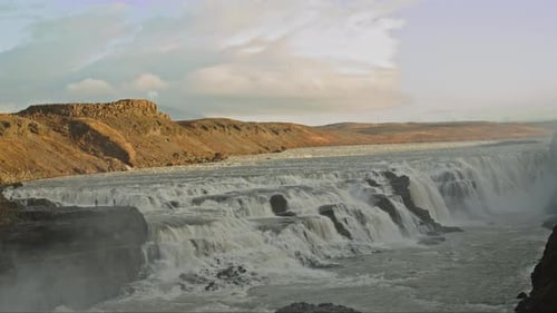 Wide view of the stunning Gullfoss Waterfall in Iceland. The camera slowly tilts down