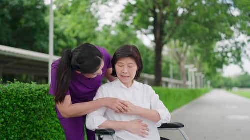 Caregiver talking to happy senior patient in wheelchair for rehabilitation, nurse help with service.