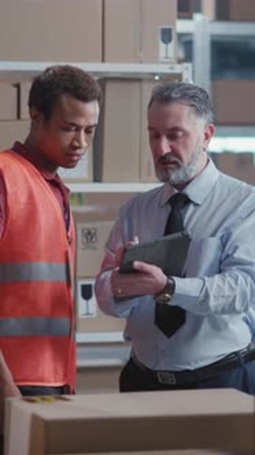 In Delivery Department Couple of Male Colleagues Discussing Delivery Making Notes and Counting