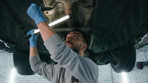 Caucasian Man Professional Mechanic in Uniform Repairman Male Engineer Working Underneath Car Check