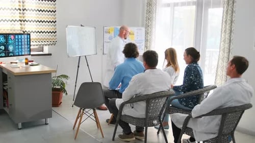 Bald Doctor Dancing at End of Hospital Seminar Under Applause