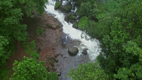 Vue panoramique par drone des chutes de Vasudhara, à Bhandardara, avec une aura de mousson nuageuse au milieu d'une forêt verdoyante