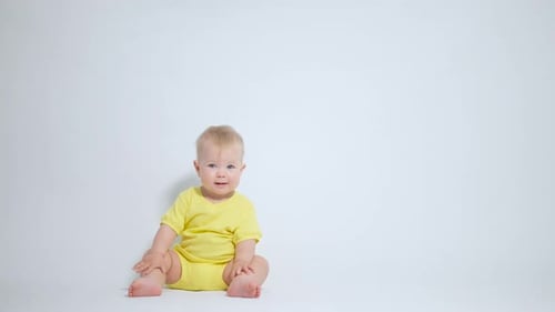 the kid is sitting on his ass with a satisfied emotion and a cunning look watching what is happening