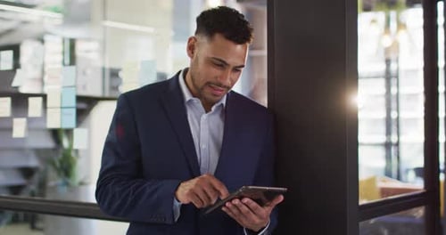 Portrait of mixed race businessman using tablet smiling looking at camera