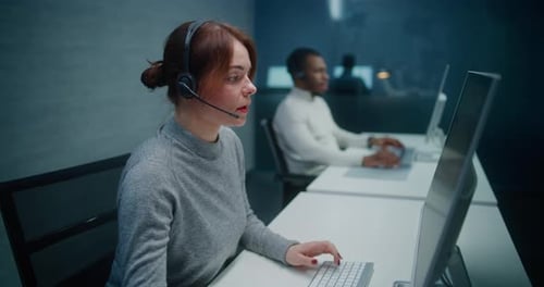 Call Center Office Female Technical Support Specialist in Headset Monitoring Data on PC