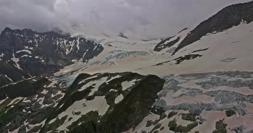 Uralter Schneegletscher inmitten hoher Berge Die Gipfel der Berge sind mit Schnee bedeckt