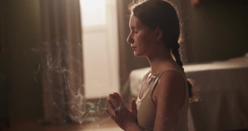 Female Meditating Near Incense in Morning