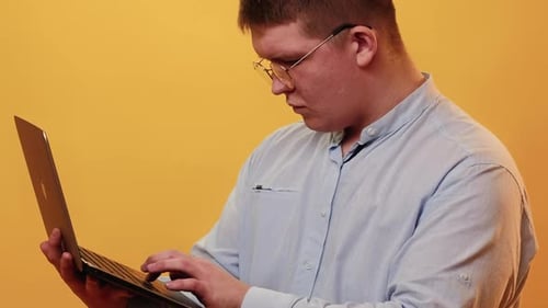 Man with Glasses Typing on Laptop
