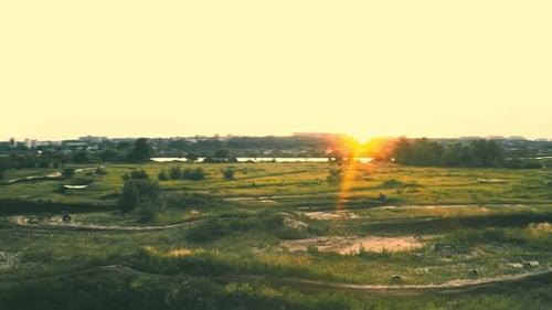 Dirt Bikes Riding on Track at Sunset