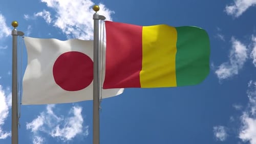 Flagge Japans gegen Flagge Guineas am Fahnenmast