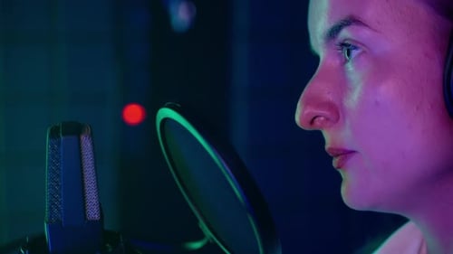 Portrait of Woman Radio Host Singer or Blogger Recording Podcast Closeup View of Mic and Face