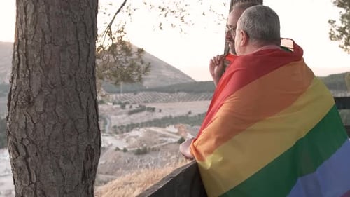 Gay Couple Standing on Hillside at Sunrise