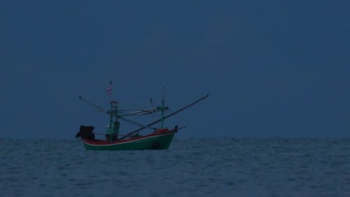 Fishing Boats in Thailand wait in the middle of the ocean for dark to come so they can turn on their