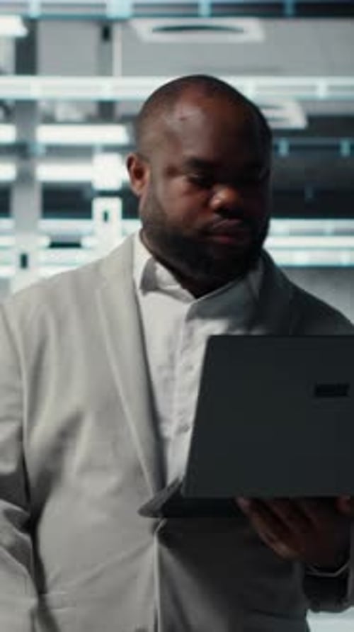 Vertical Video Technician Walks in Data Center Configuring Storage Devices for Minimal Latency