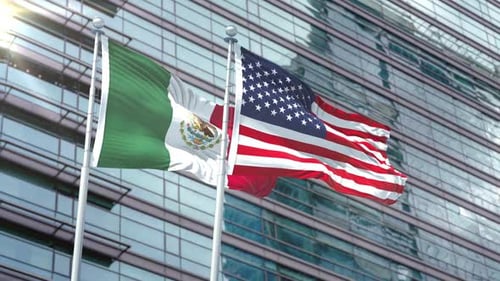 Mexico and USA National Flags Waving on Modern Building