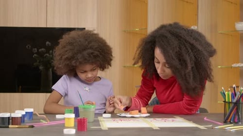 Child and Adult Painting Together at Home