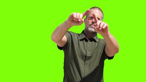 A man engaging with a virtual set against a green screen background.