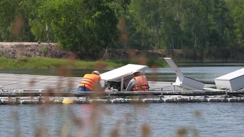 Floating Solar Panel on the pond. Worker is service and check on floating solar photovoltaic panels.